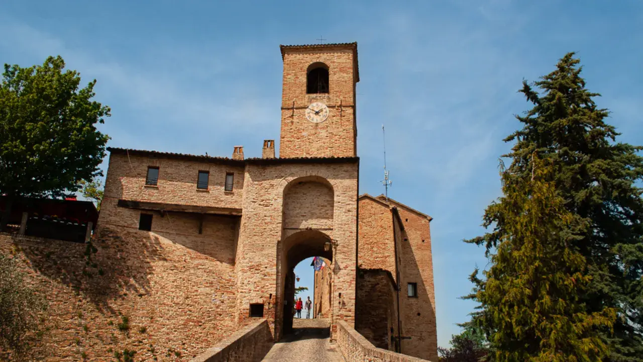 Porta Urbica a Montefeltro: un arco in mattoni con torre dell'orologio, ideale per scoprire cosa vedere in questo borgo storico.