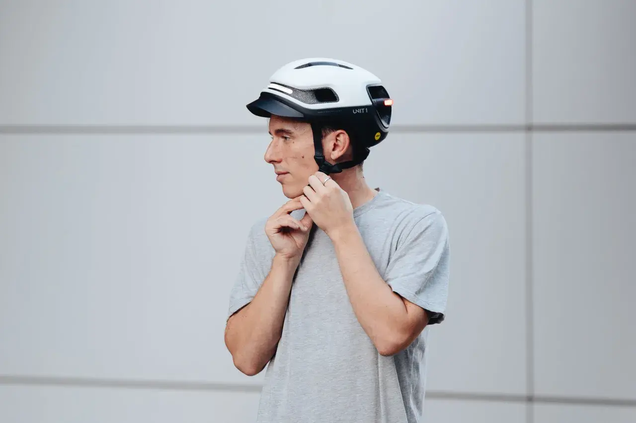Uomo con casco bianco e nero, con luci LED integrate. Le misure del casco moto sono importanti per la sicurezza.