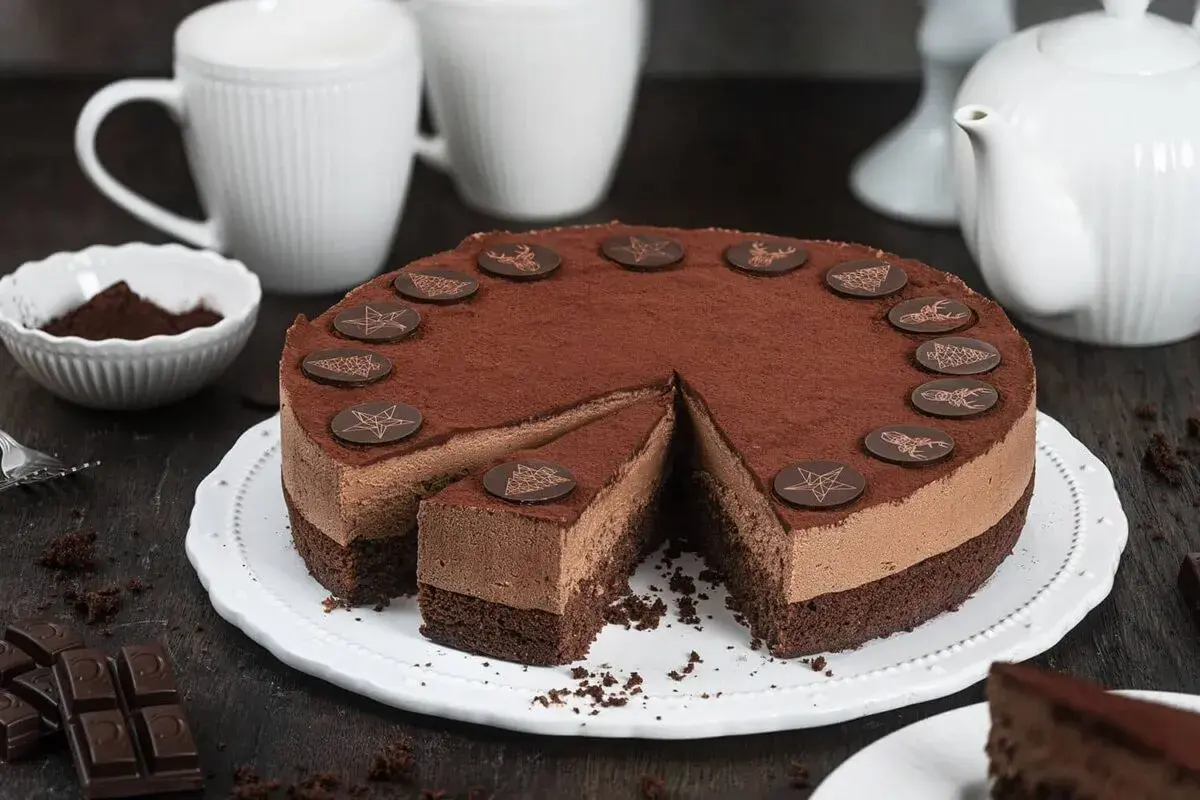 Eine köstliche Schoko Torte, bestäubt mit Kakao und verziert mit Schokoladen-Anis-Motiven, wartet auf Genießer.
