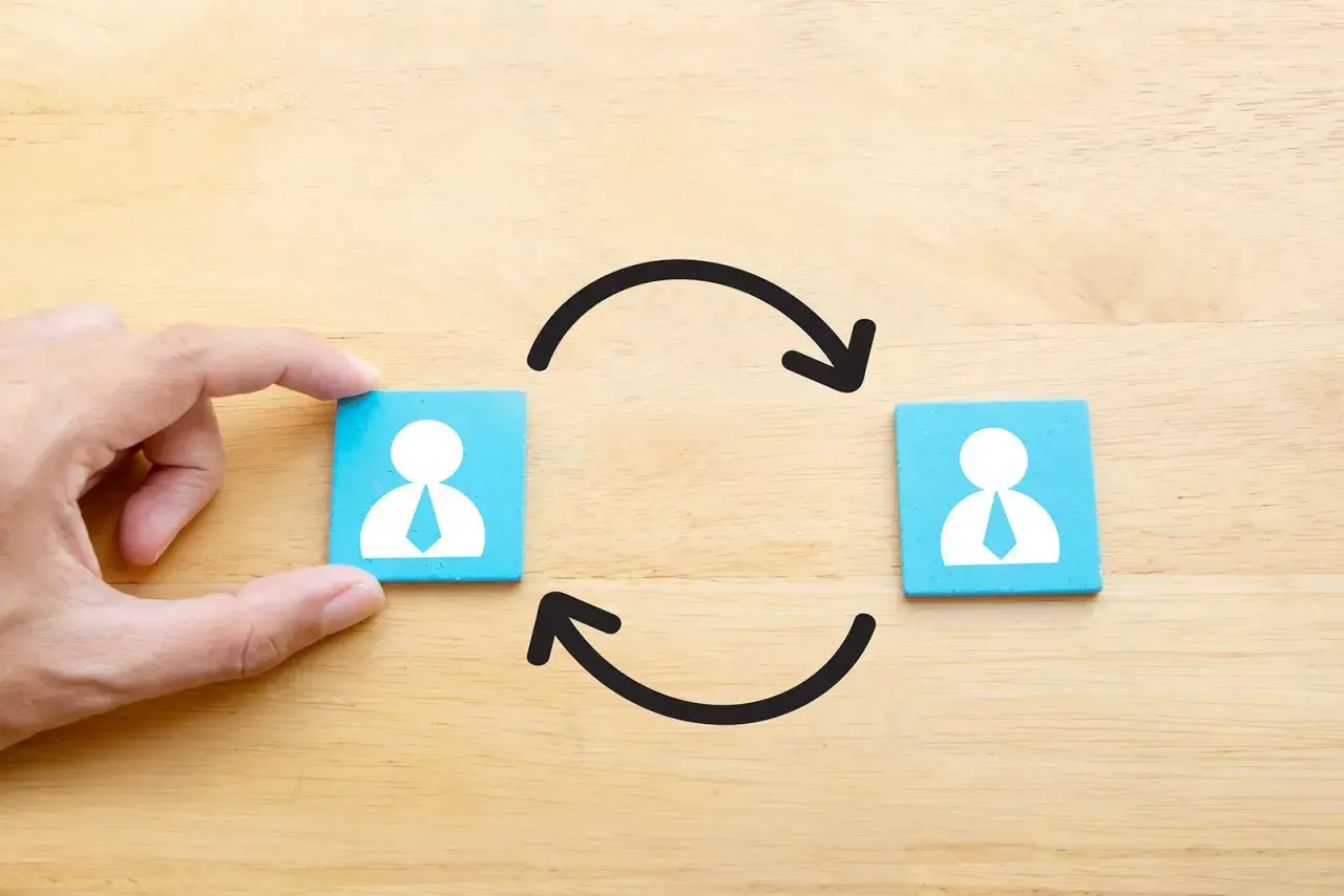 Dadi con icone di persone e frecce circolari, illustrano il turnover significato di cambio.