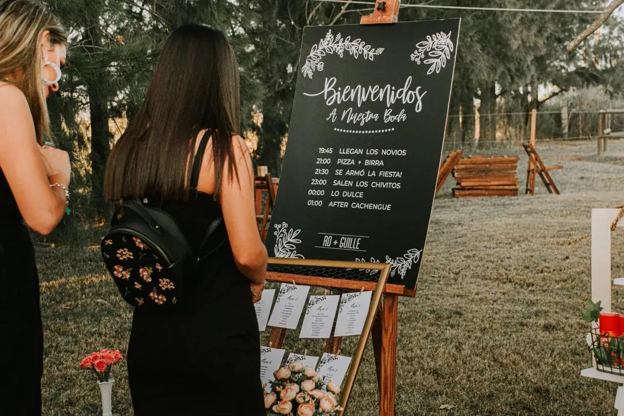 Cartel sobremesa de bienvenida a una boda con horarios y nombres de los novios.