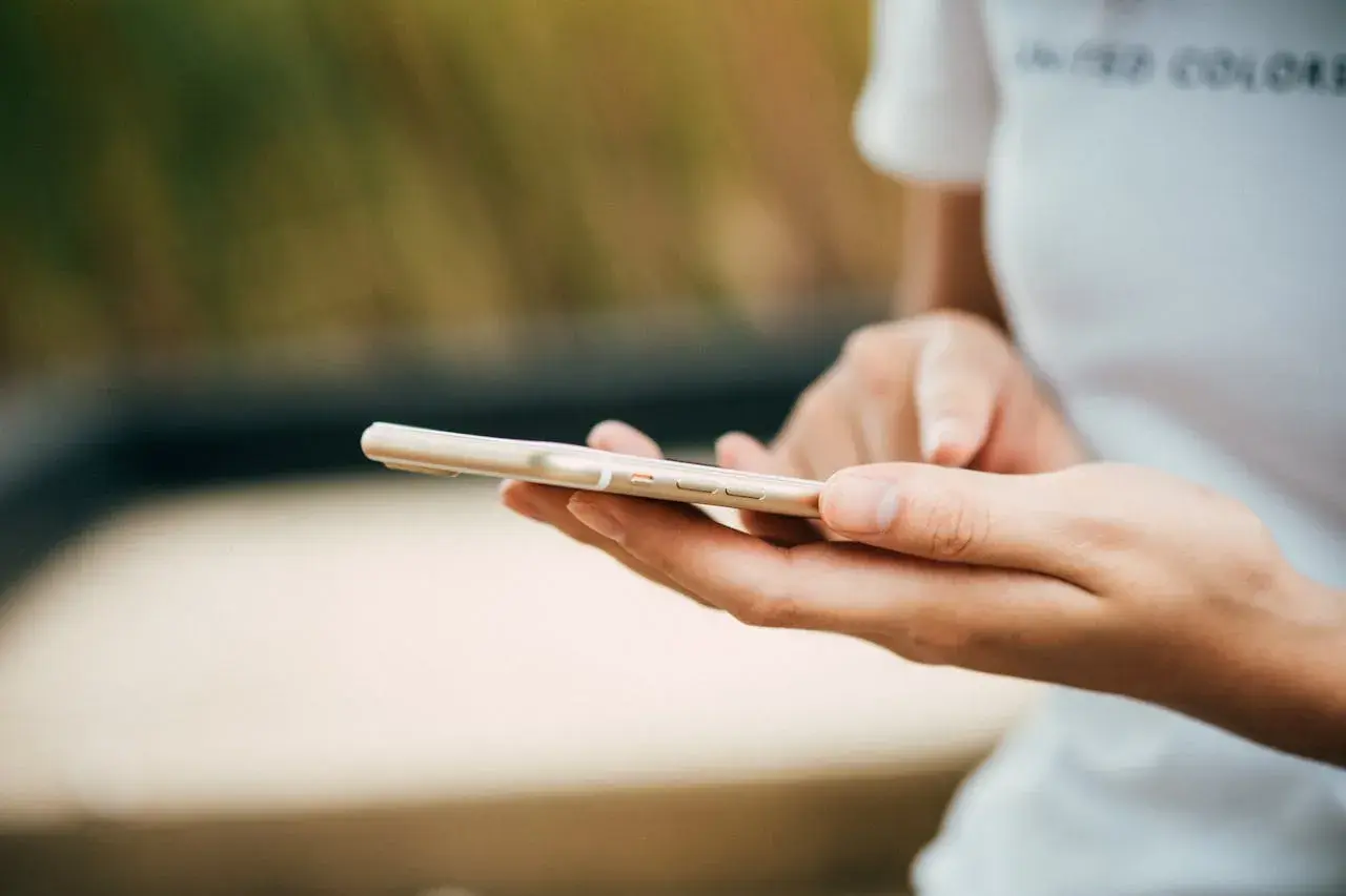 Mani che scorrono su uno smartphone dorato. Come in un ciclo, chi fa orbiting ritorna sempre a connettersi.