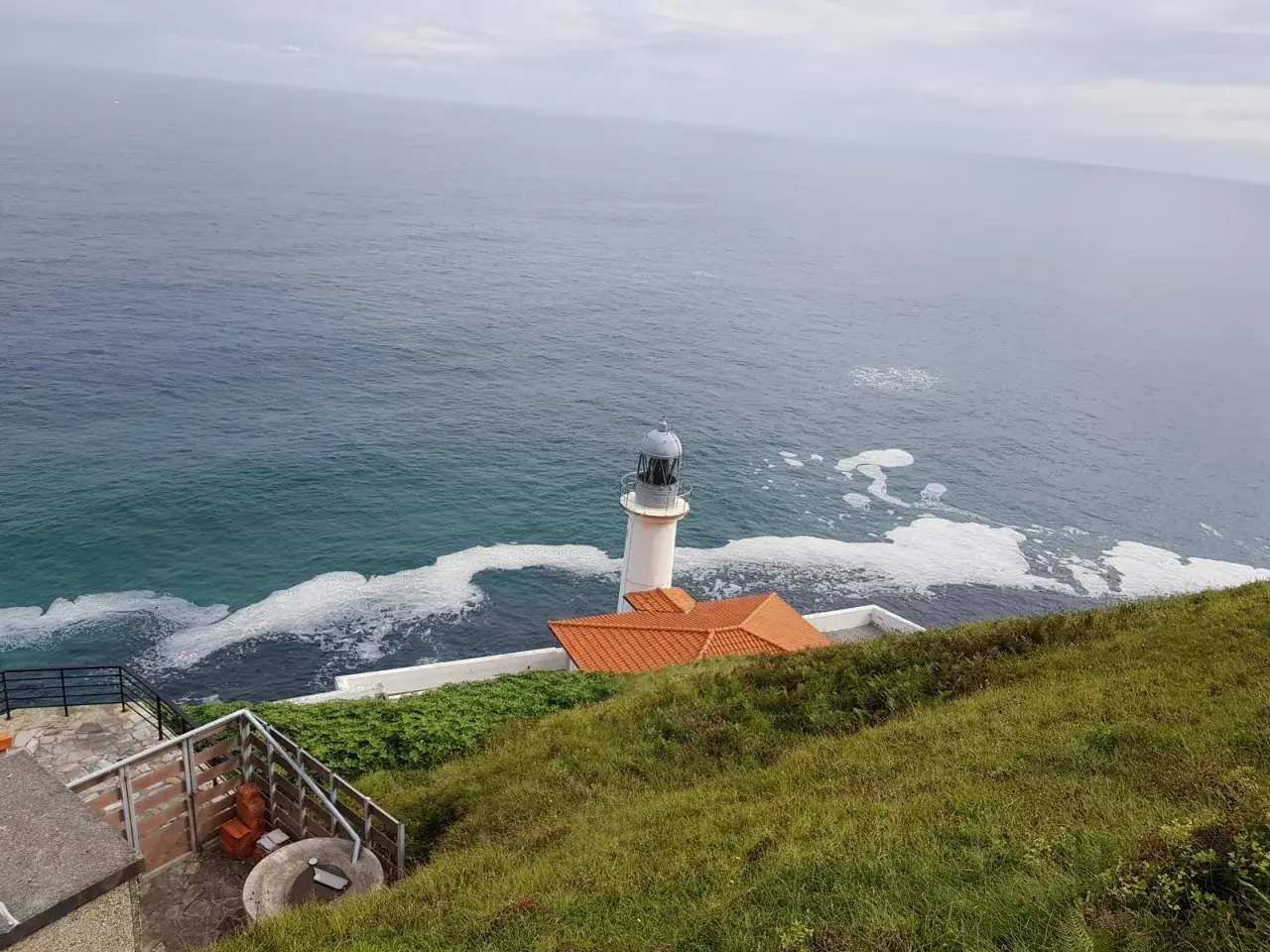 El faro del pescador en Santoña se alza vigilante sobre el mar Cantábrico, con espuma blanca adornando las olas.