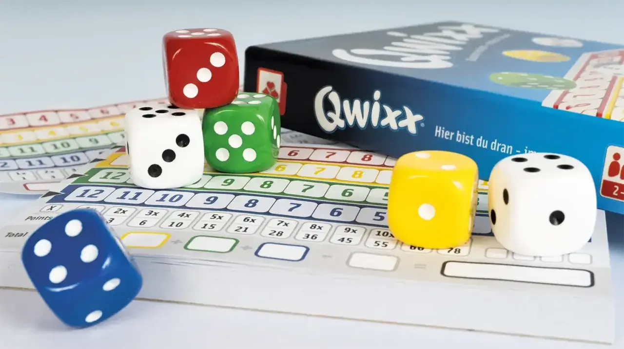 Bunte Würfel und Spielkarten für das beliebte Würfelspiel Qwixx. Hier sind die Rollen für spannende Runden bei den Brettspielen.