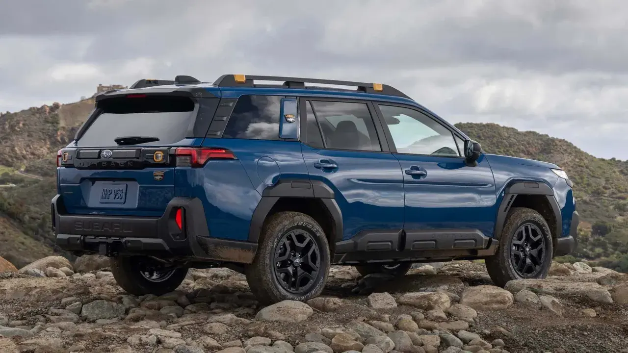 Niebieski Subaru Outback 2026 na kamienistym, górzystym terenie, gotowy na przygodę.