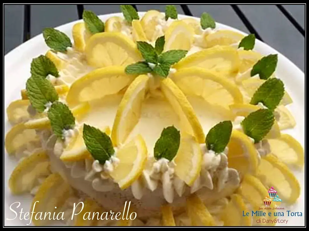 Delizia al limone, una torta fresca e profumata, decorata con fette di limone e foglie di menta.