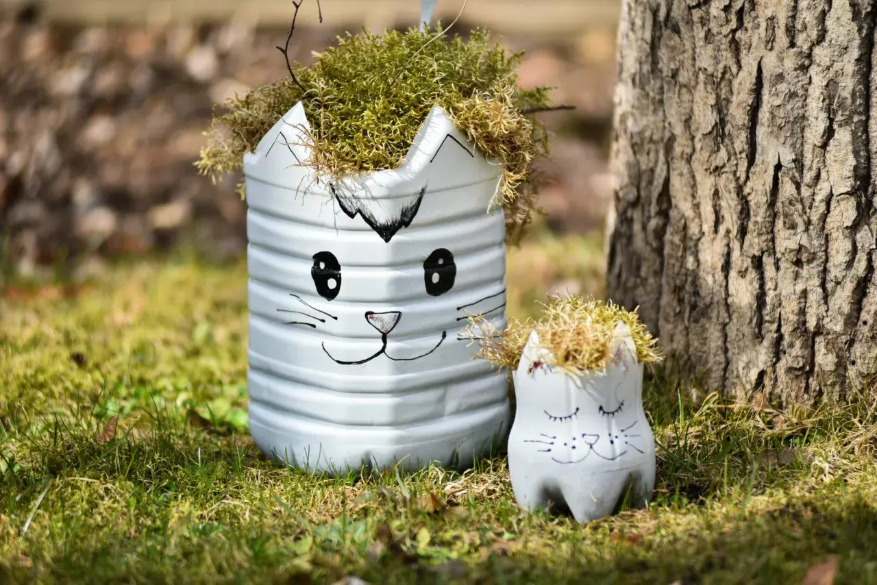 Urocze dekoracje ogrodu DIY w kształcie kotków, wykonane z recyklingu, dodają uroku zielonej trawie.