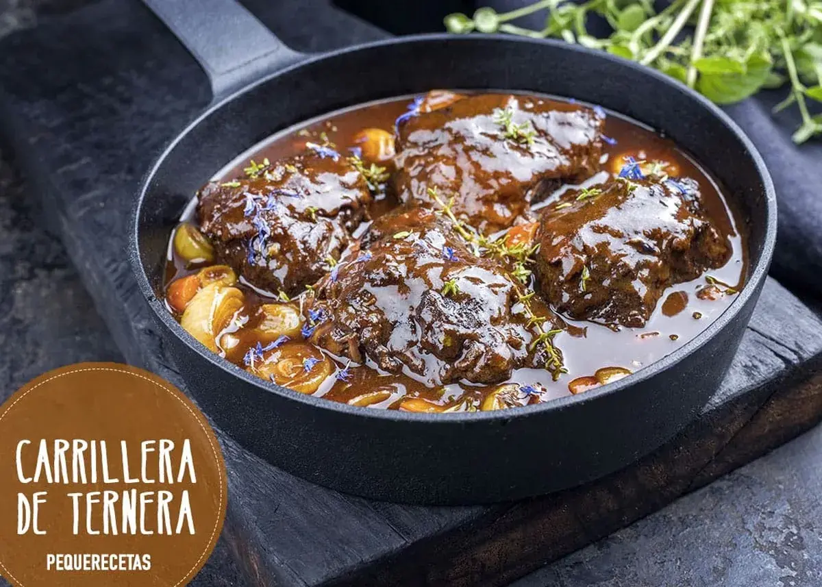 Carrilleras de ternera estofadas en salsa oscura, con trozos de verdura y hierbas. ¡Un clásico de la receta de la abuela!