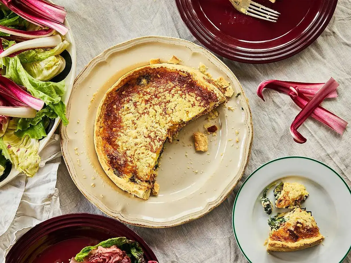 En saftig quiche lorraine med en gyllene skorpa, serverad med en fräsch sallad.