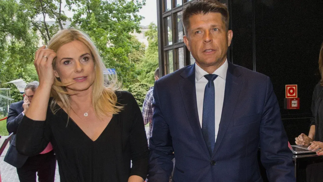 Para, która może być odpowiedzią na pytanie, czy Ryszard Petru ma żonę, idzie obok siebie. Kobieta ma blond włosy i czarną bluzkę, mężczyzna w granatowym garniturze.