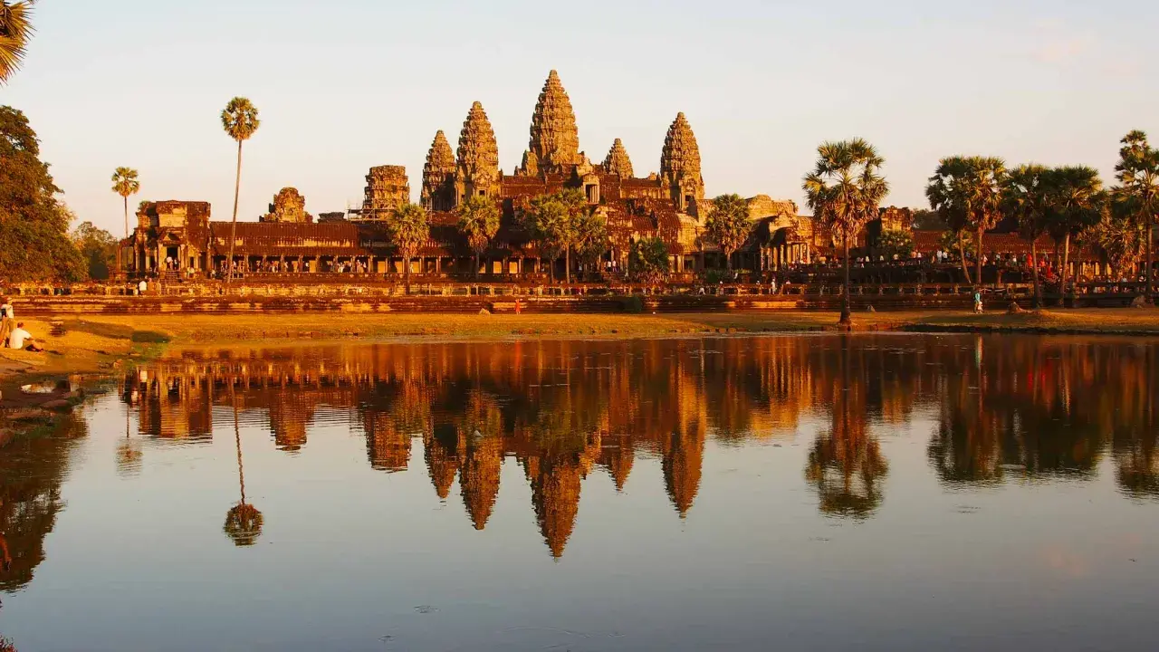 Angkor Wat au coucher du soleil, un incontournable pour savoir que faire au Cambodge. Les tours se reflètent dans l'eau.