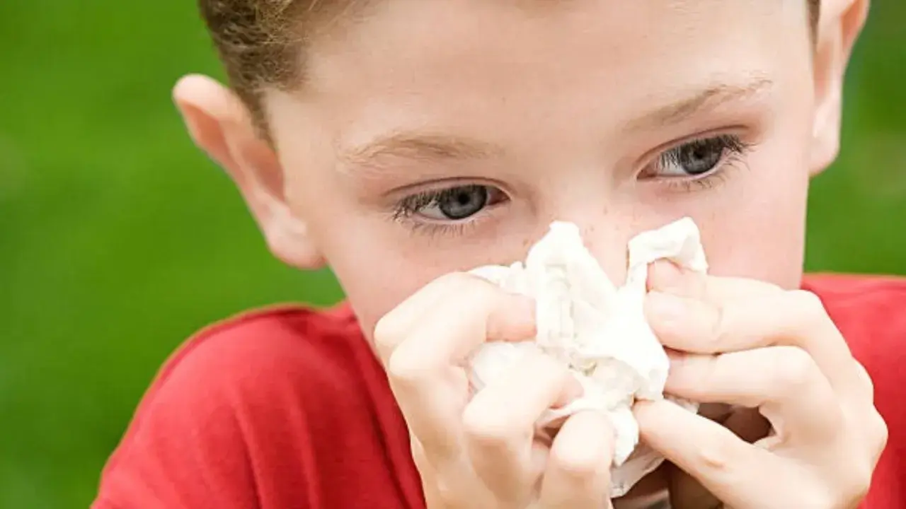 Niño con pañuelo en la nariz, mostrando síntomas de alergia en niños.