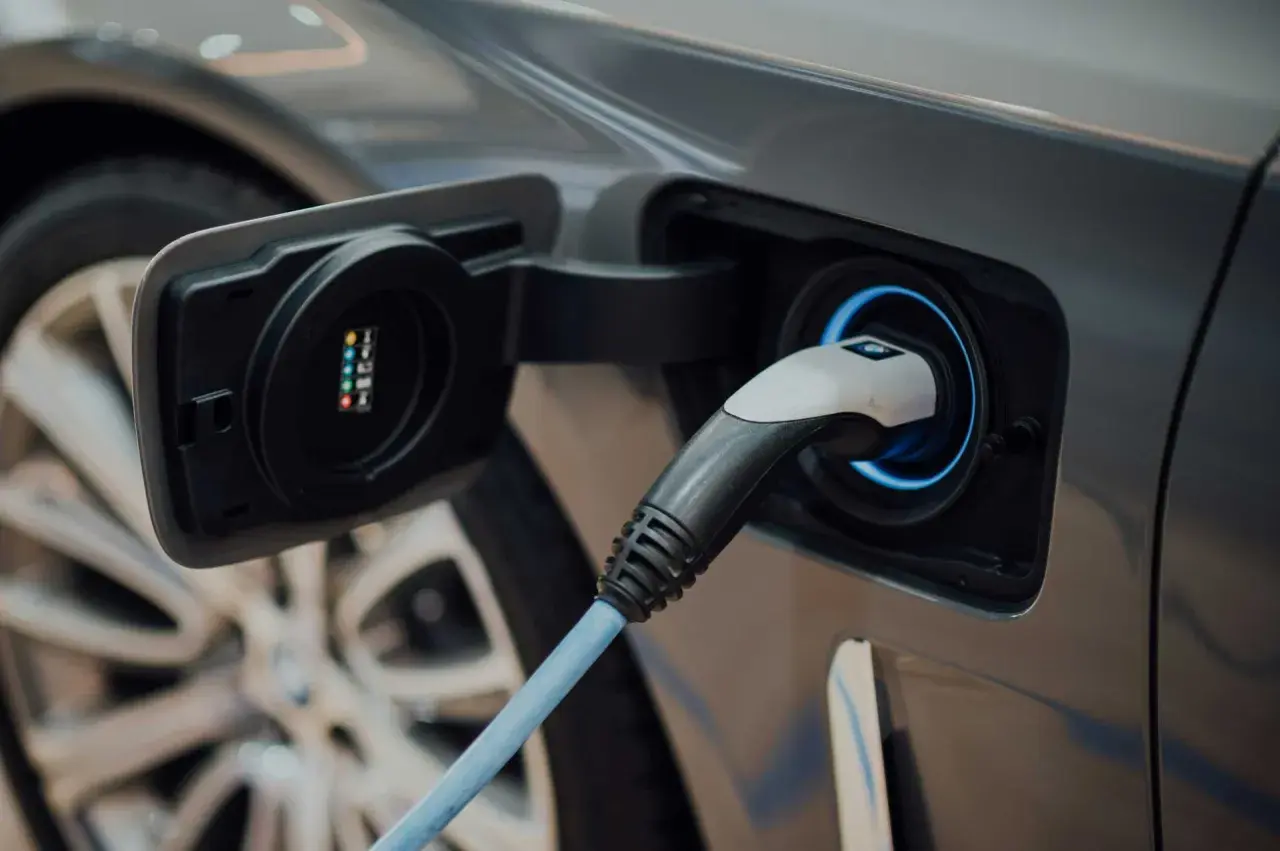 Prise de recharge d'une voiture électrique, le câble bleu est branché, prêt à alimenter les batteries.