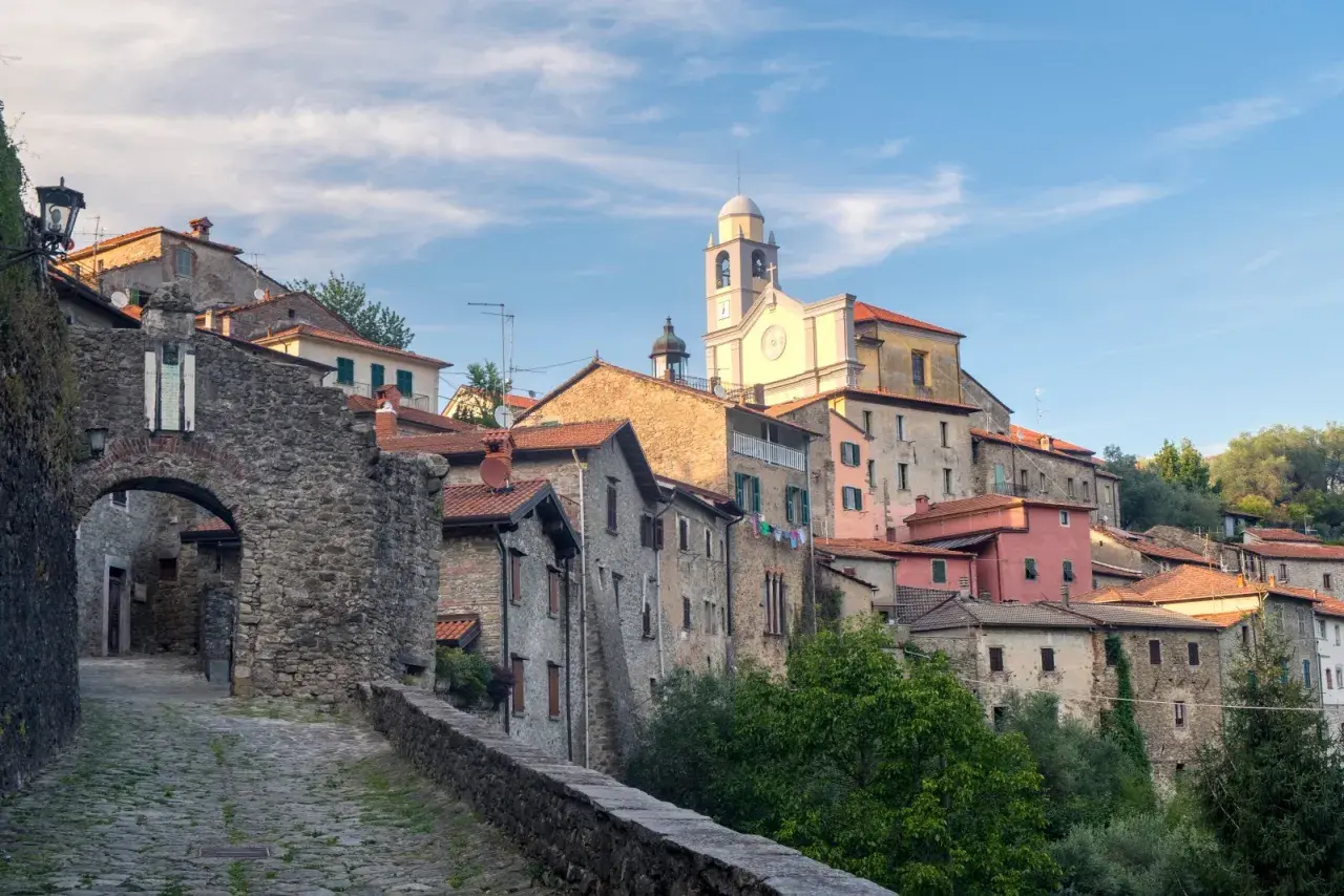 Antico borgo in pietra della Lunigiana, dove si trova un'antica porta d'accesso e una chiesa con campanile.