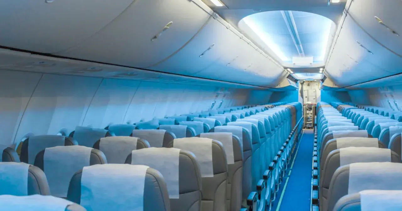 Wnętrze samolotu Boeing 787 LOT. Widok na rzędy pustych siedzeń, które tworzą rozkład miejsc w kabinie pasażerskiej.