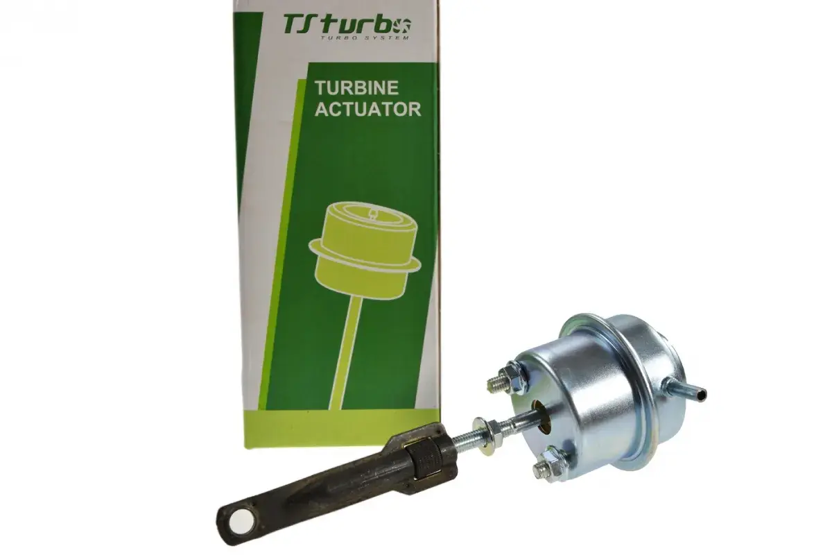 Zawór podciśnienia turbiny Ford Focus 1.6 TDCI. Element metalowy z grzybkiem i regulowanym ramieniem, obok zielono-białe opakowanie z napisem "TURBINE ACTUATOR".