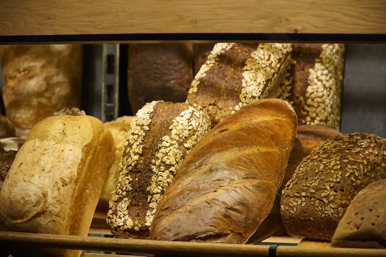 Różnorodne pieczywo, w tym bochenki z płatkami owsianymi i słonecznikiem. Szukasz pieczywo, jakie nie zawiera glutenu?