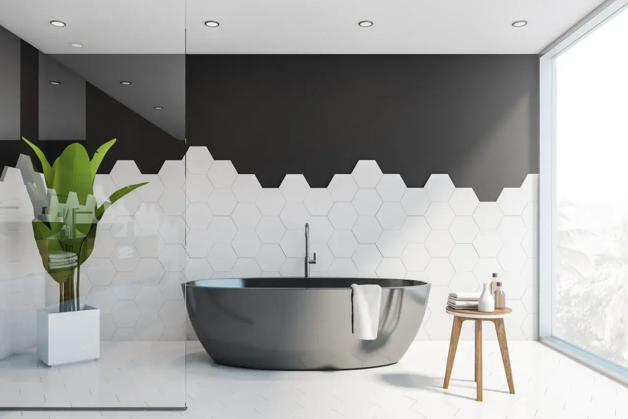 Bagno moderno con vasca scura e piastrelle esagonali bianche. Idee per dipingere piastrelle bagno: contrasto tra nero e bianco.