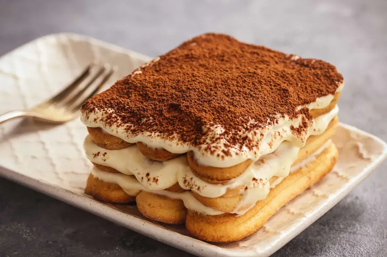 Pyszne tiramisu z kremem i biszkoptami, posypane kakao. Zastanawiasz się, jaki alkohol do tiramisu?