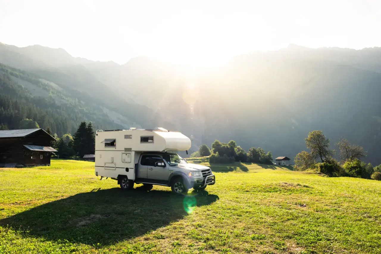Camping-car dans un paysage montagneux ensoleillé, un endroit idéal pour le meilleur pays pour voyager en van.