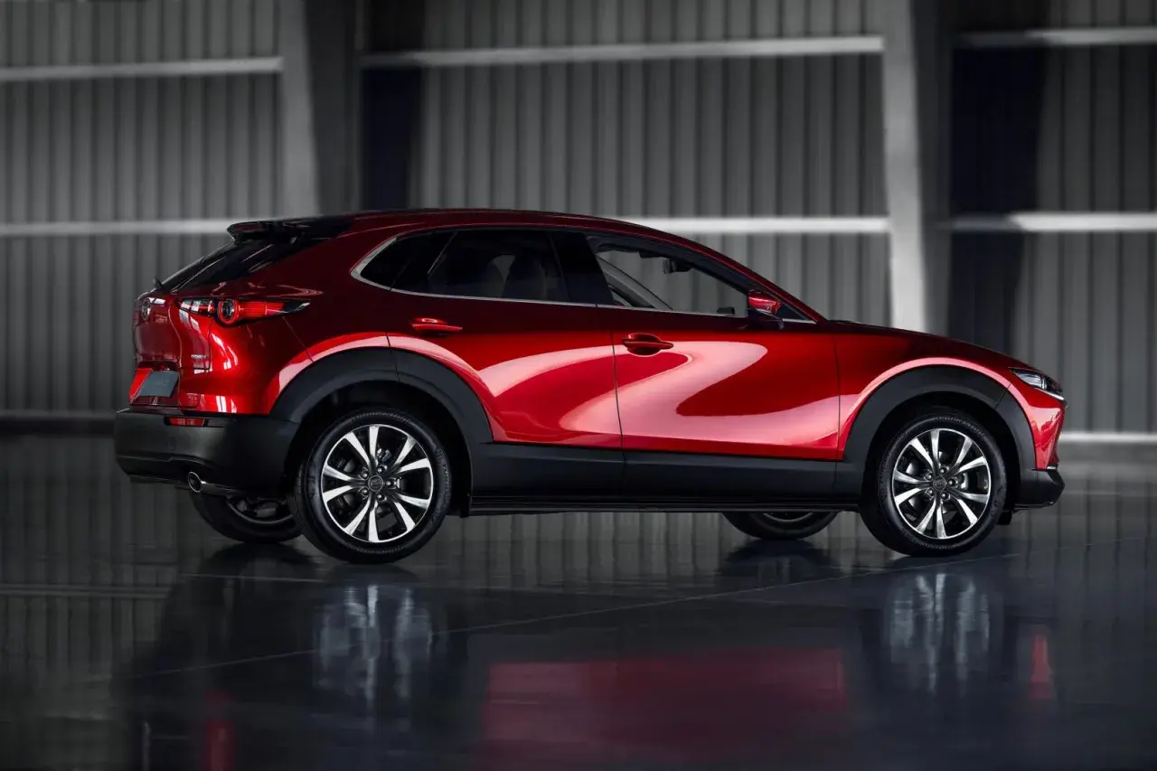 Błyszczący czerwony Mazda CX-30 z profilu. Poznaj jego kompaktowe mazda cx 30 wymiary, idealne do miasta.