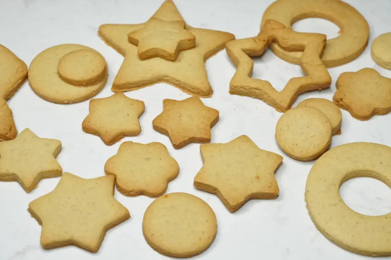 Variedad de galletas caseras horneadas con formas de estrellas, círculos y un anillo.