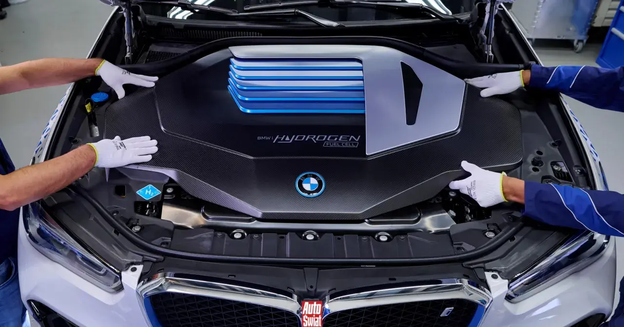 Ręce w białych rękawiczkach montują osłonę silnika BMW i Hydrogen Fuel Cell.