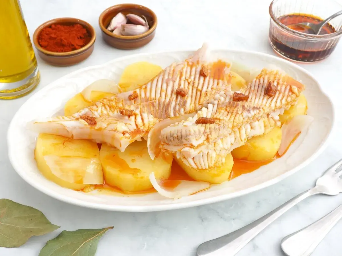 Raya a la gallega servida con patatas y cebolla, aderezada con aceite, pimentón y ajo.