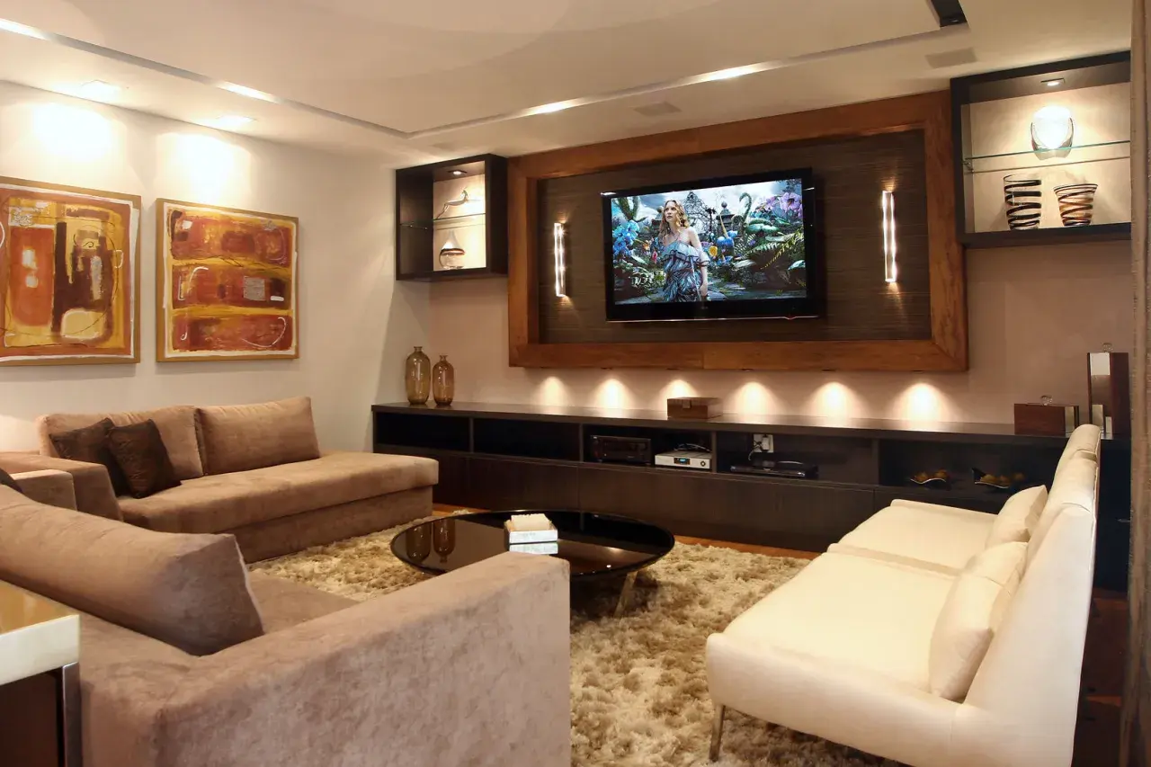 Accogliente soggiorno con divani, TV e quadri. Soluzioni d'arredo per una stanza senza finestra, creando un'atmosfera luminosa e moderna.