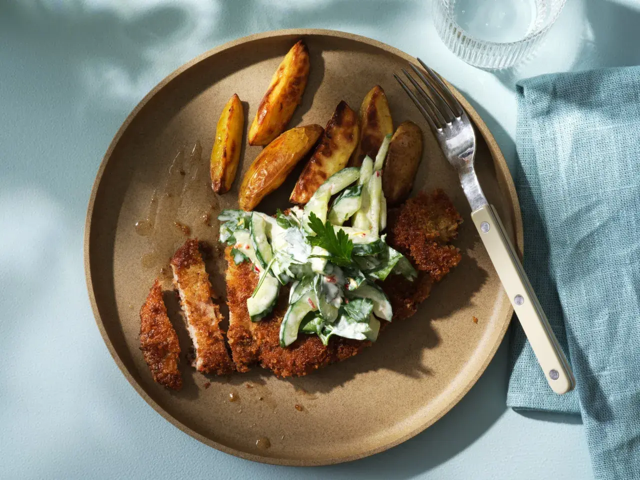 Krispigt schnitzel recept med klyftpotatis och krämig gurksallad. En perfekt middag!