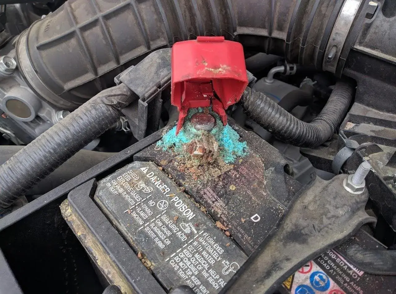 Vano batterie auto con forte ossidazione bluastra sui morsetti. Guida su come pulire vano batterie ossidato.