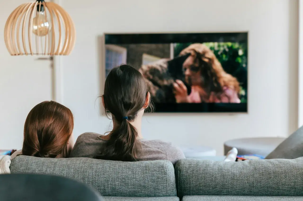 Dwie osoby oglądają film na telewizorze. Szukają sposobu, jak znaleźć film, którego tytułu nie pamiętam, opisując scenę z ekranu.