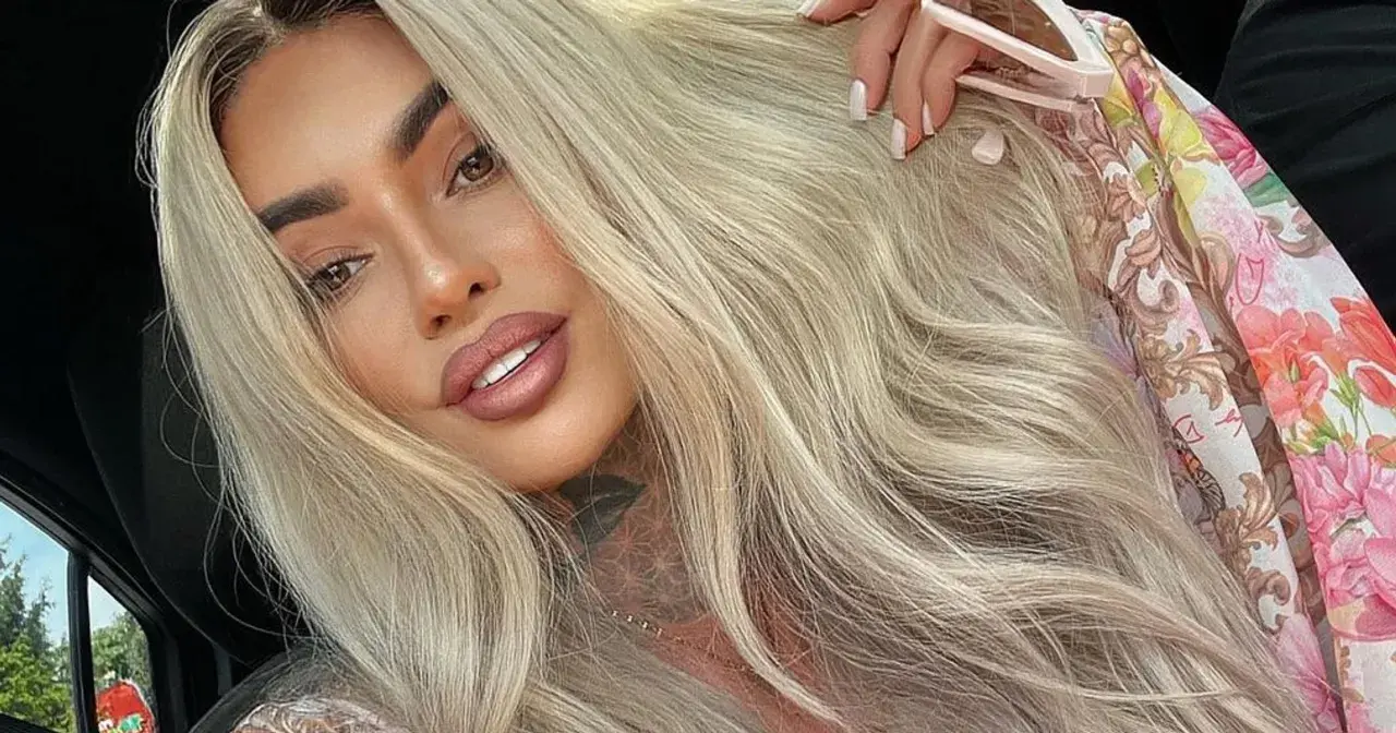 Ania Królowe Życia z blond włosami i tatuażem na szyi, w kwiecistej bluzce.