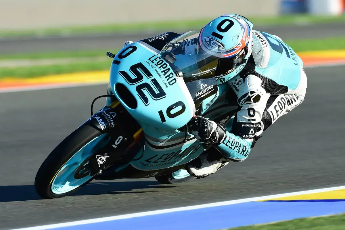 Danny Kent inclinado en su moto azul y negra, número 52, compitiendo en una carrera.