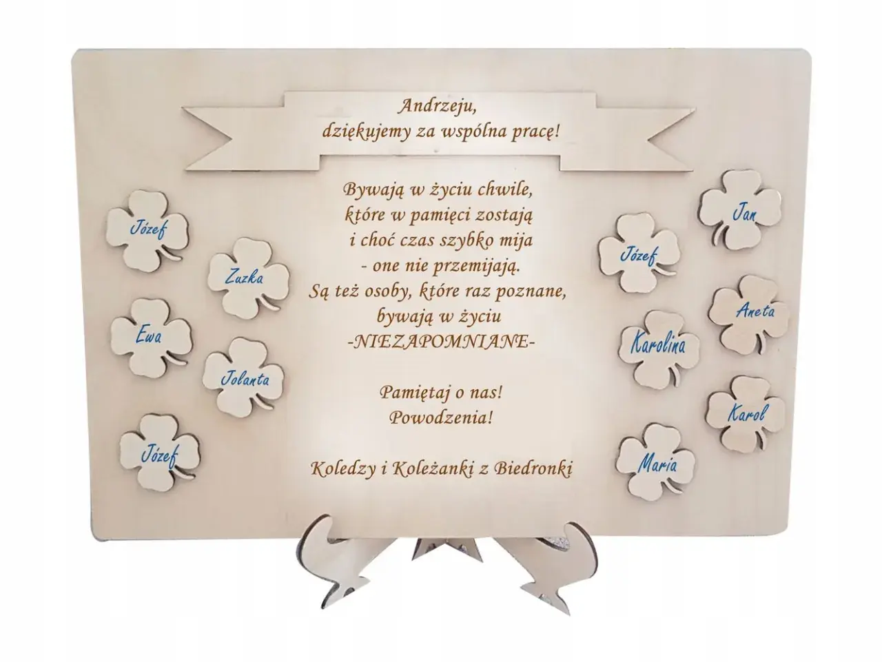Drewniana tablica z podziękowaniami dla Andrzeja od kolegów z Biedronki. Na tablicy wypisane są słowa podziękowania i imiona: Józef, Zuzka, Ewa, Jolanta, Jan, Aneta, Karolina, Karol, Maria.