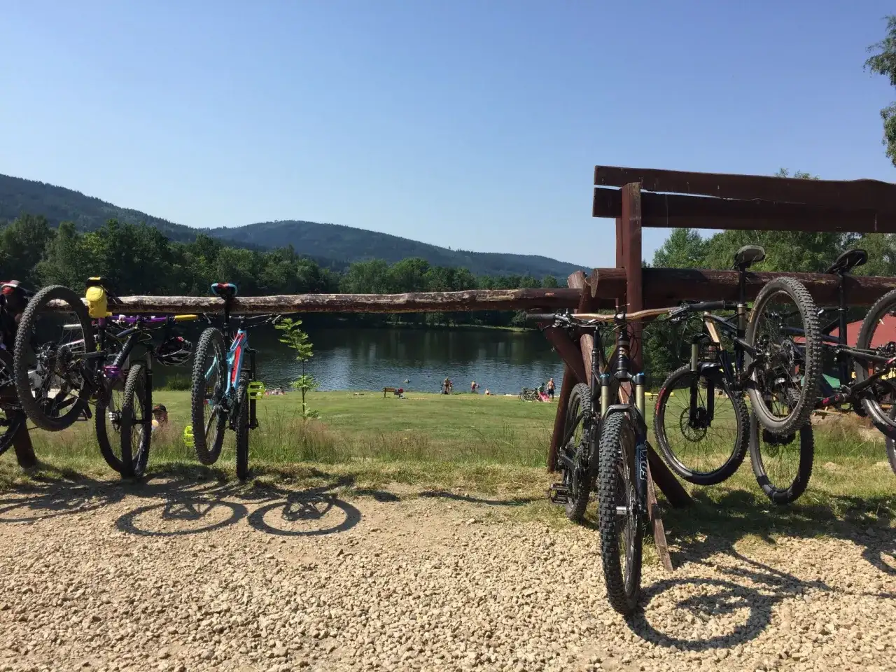 Rowerowe przygody czekają! Wiele rowerów gotowych do podboju tras rowerowych Świeradów Zdrój, nad jeziorem z plażowiczami.