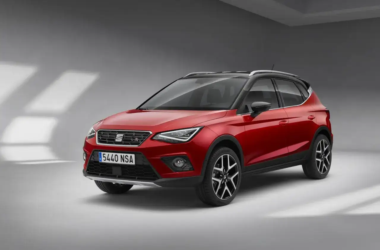 Czerwony Seat Arona z czarnym dachem, gotowy na miejskie przygody.