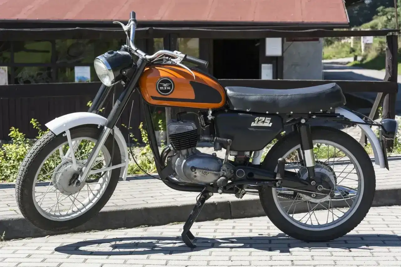 Pomarańczowy motocykl WSK 125 modele, klasyk z lat 70., gotowy do podróży.