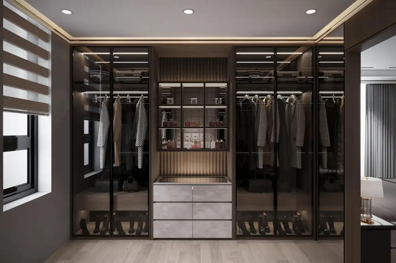 Elegancka garderoba z przeszklonymi szafami, wyeksponowanymi ubraniami i butami. Perfumy na półkach podkreślają styl moda quiet luxury.