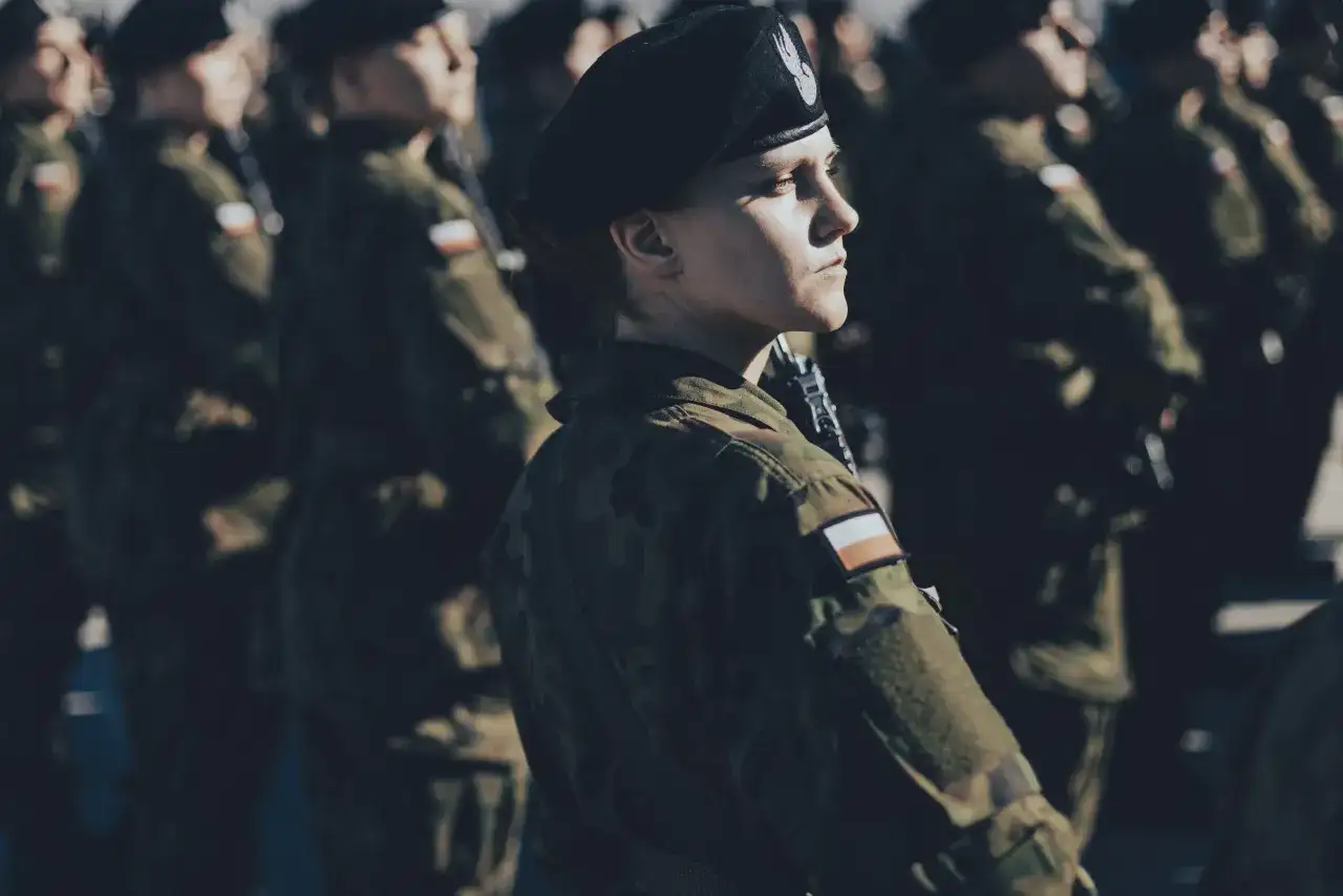 Kobieta w beretce i mundurze, gotowa do służby. To jej dobrowolna zasadnicza służba wojskowa.