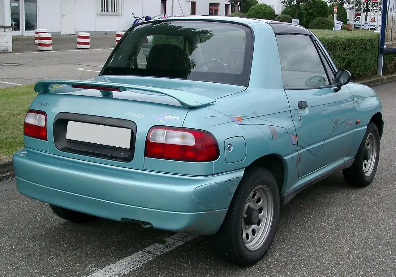 Niebieski Suzuki X90 z charakterystycznymi naklejkami na boku, widok z tyłu.