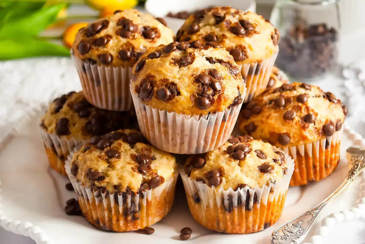 Stos muffinek bananowo czekoladowych, pachnących domem i słodyczą, gotowych do zjedzenia.