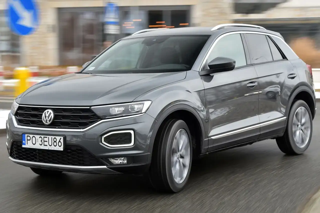 Szary Volkswagen T-Roc w ruchu miejskim. Wiele osób szuka volkswagen t-roc opinie, by podjąć decyzję o zakupie.