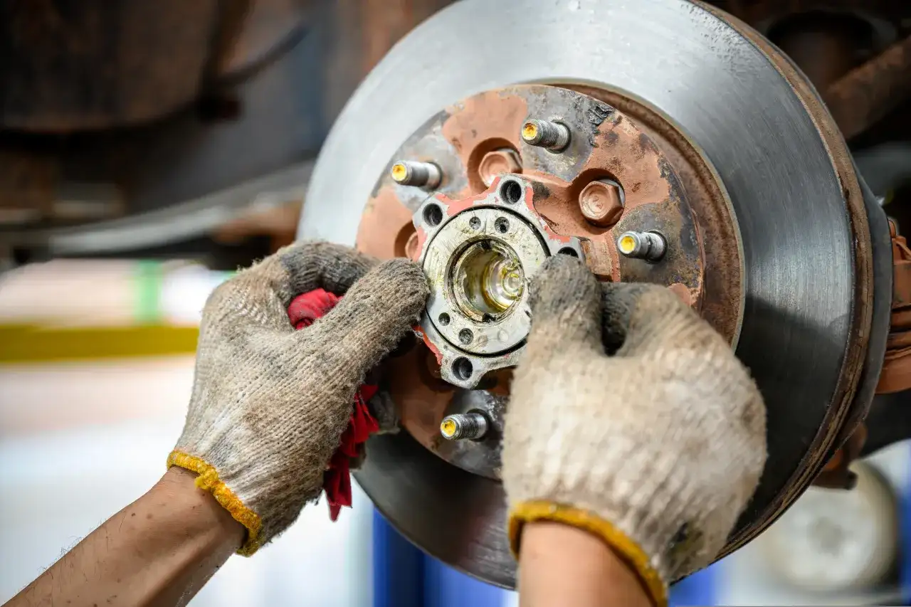 Mechanik sprawdza piastę koła, która może być przyczyną objawów zużytego łożyska koła: huczenie w zakrętach.