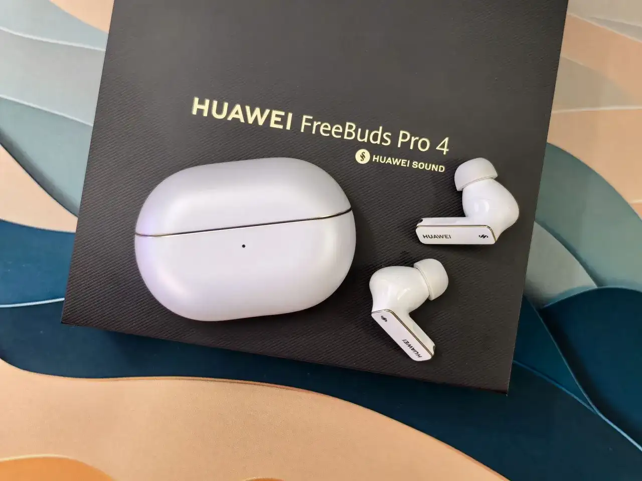 Białe słuchawki TWS Huawei FreeBuds Pro 4 z etui na czarnym tle z logo.