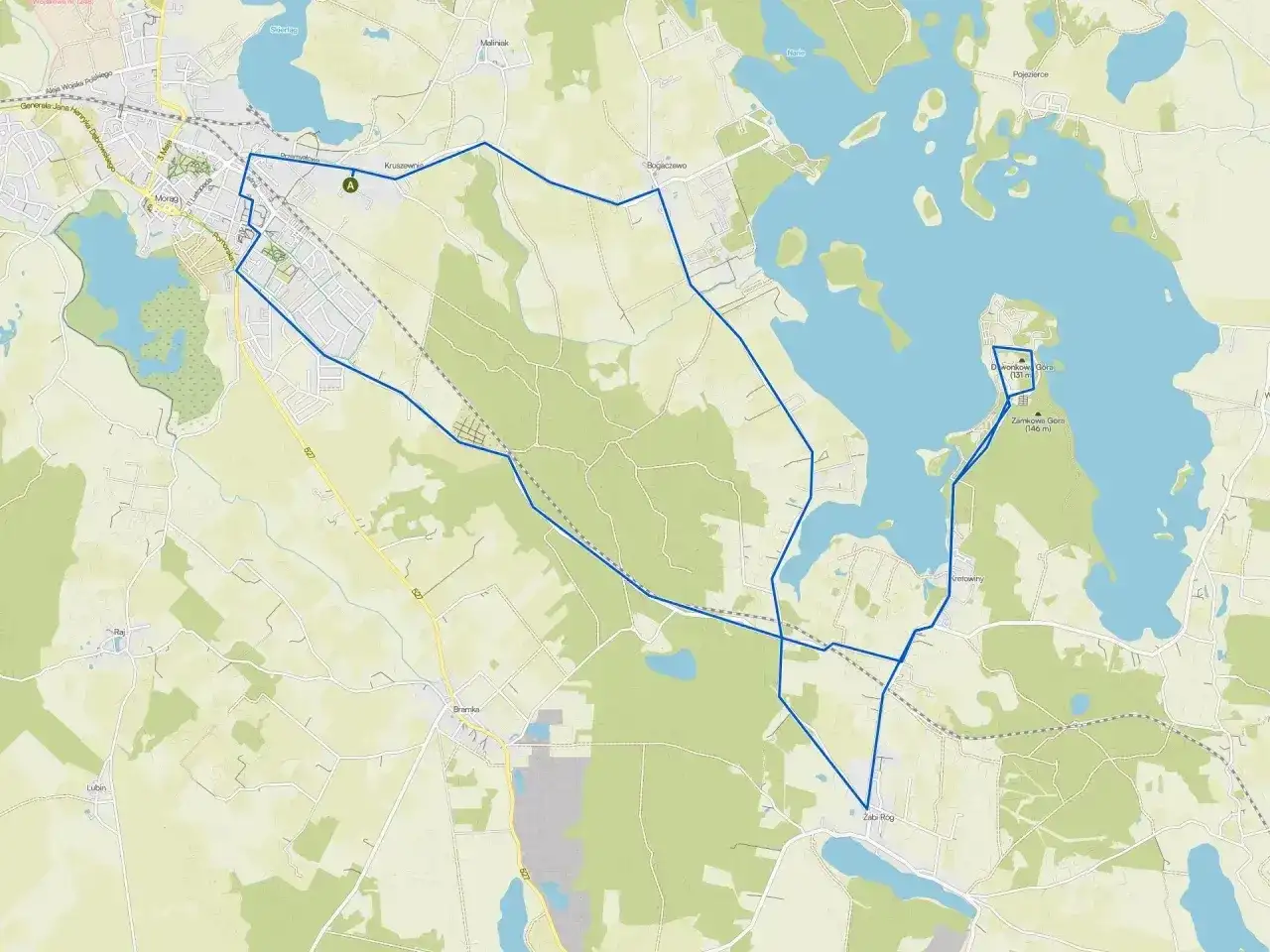 Mapa turystyczna z zaznaczoną trasą wokół miasta nad jeziorem Skiertąg. Widoczne jezioro, lasy i zabudowania.