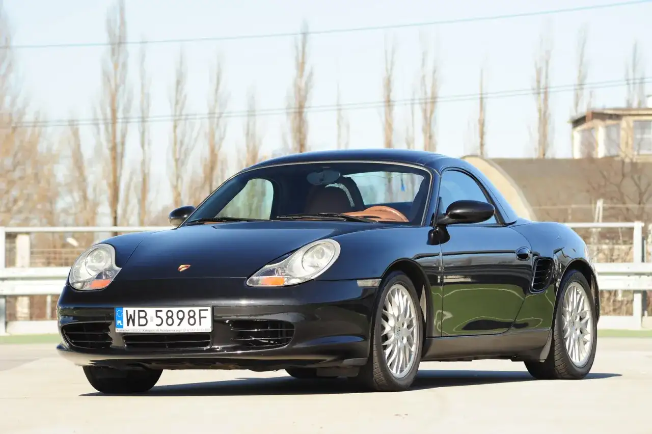 Czarny Porsche Boxster 986 z beżowym wnętrzem, gotowy na wiosenne przejażdżki.