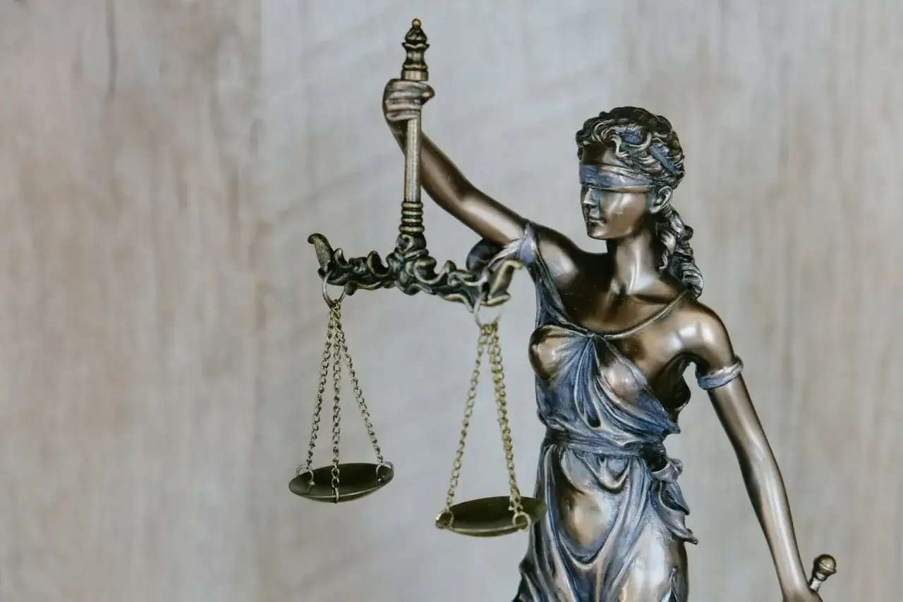 Figurka Temidy z wagą, symbol sprawiedliwości i siły wyższej.