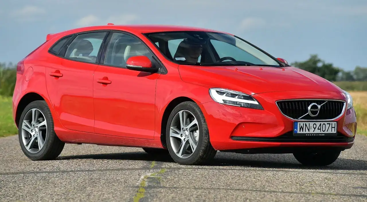 Czerwone Volvo V40 D3 na drodze, z widoczną sylwetką kierowcy.