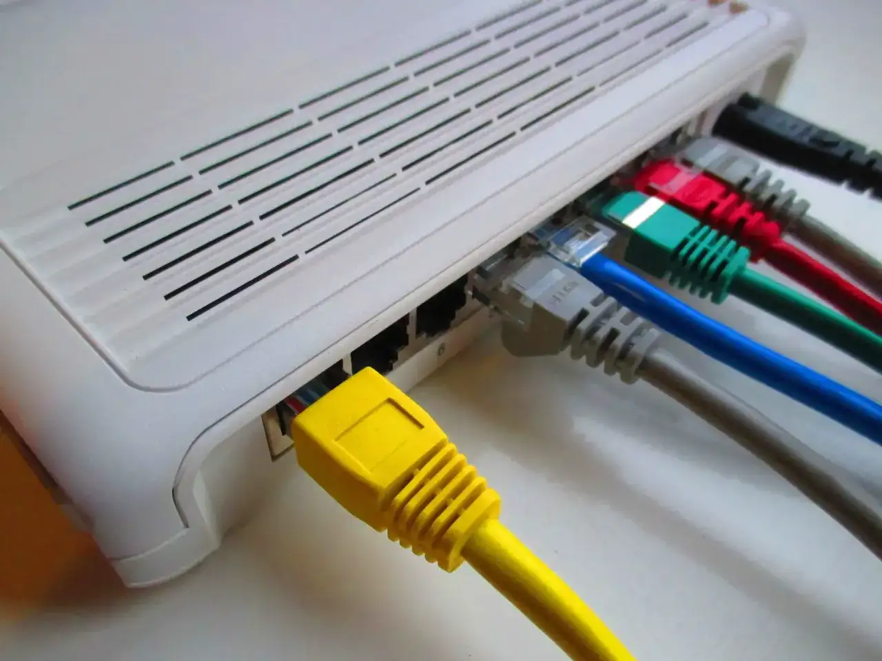 Router z wieloma kolorowymi kablami Ethernet, gotowy do połączenia z siecią PPPoE.